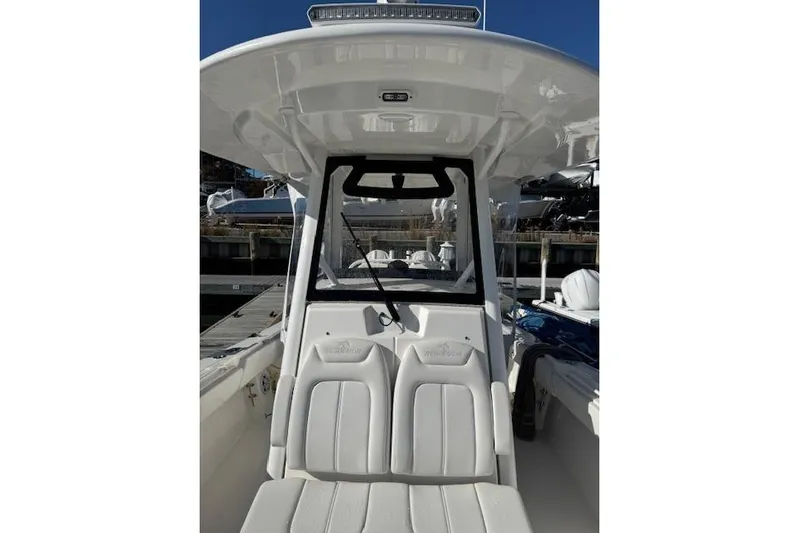  Yacht Photos Pics 2023 Regulator 31 boat interior with white seating and console, docked at marina.
