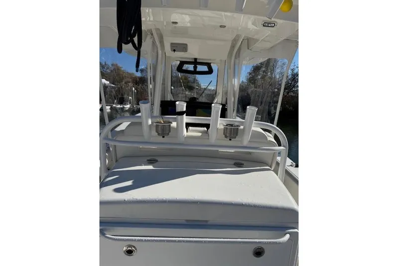  Yacht Photos Pics 2023 Regulator 31 boat interior with rod holders and console, under clear blue sky.