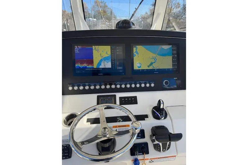  Yacht Photos Pics 2023 Regulator 31 boat dashboard with navigation screens and steering wheel.