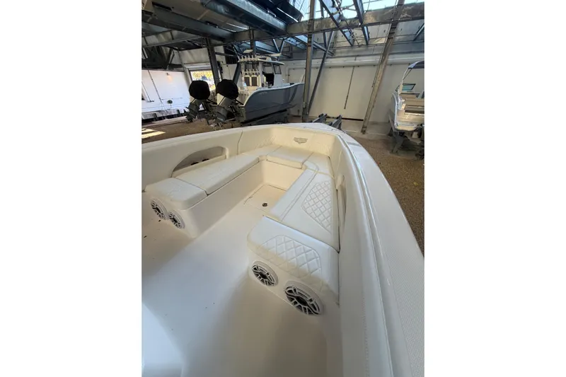 Yacht Photos Pics 2025 Deep Impact 369 Sport boat interior with white seating and speakers in a showroom.