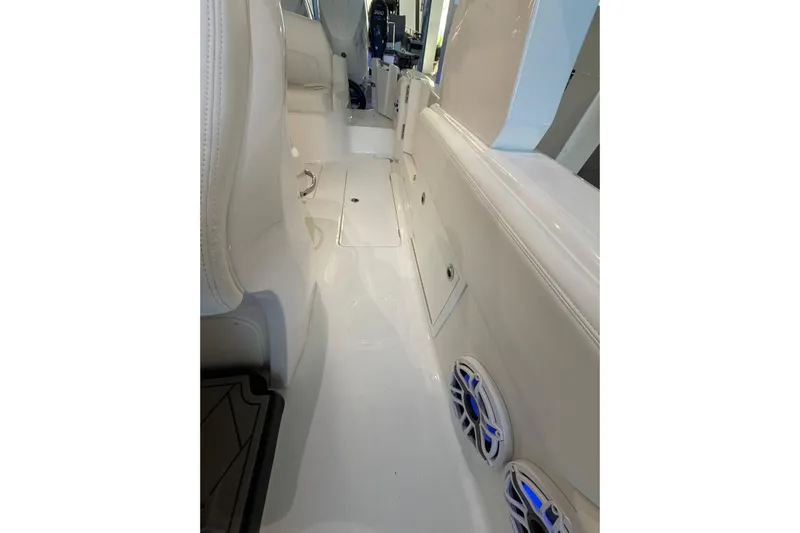  Yacht Photos Pics Interior view of 2025 Deep Impact 369 Sport boat, featuring sleek white seating and blue-lit speakers.