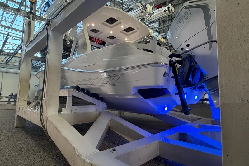  Yacht Photos Pics 2025 Deep Impact 369 Sport boat on lift, illuminated with blue lights in a marina.