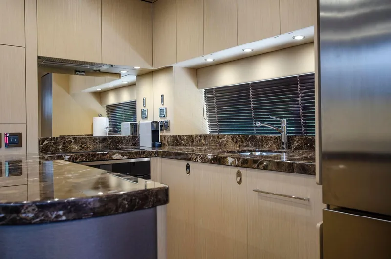  Yacht Photos Pics Modern kitchen interior on 2018 Sunseeker 75 Yacht with marble countertops and stainless steel appliances.