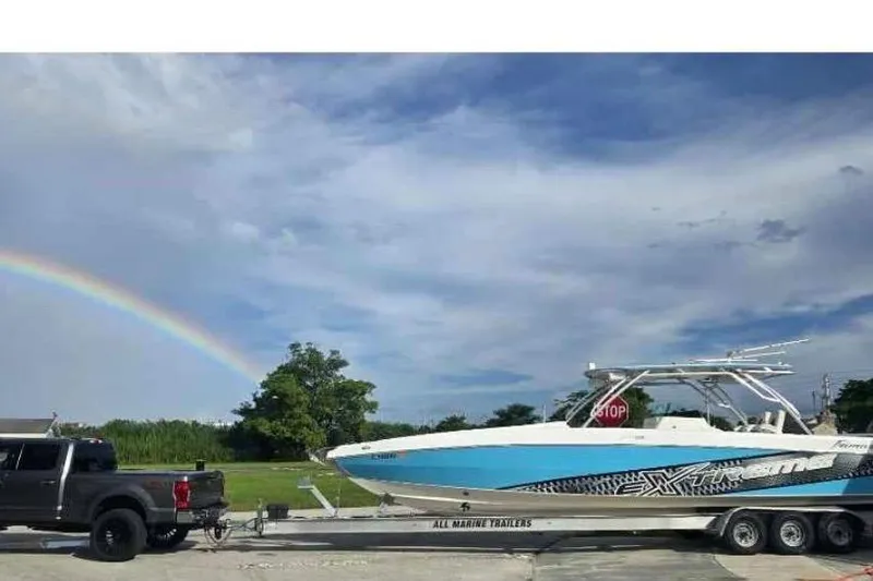  Yacht Photos Pics 2016 Extreme Boats 38 on trailer, rainbow in sky, parked beside black truck.