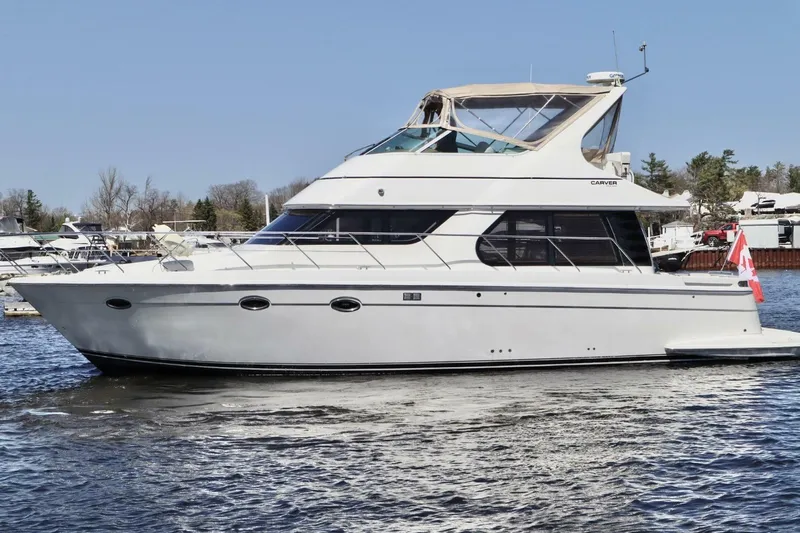  Yacht Photos Pics 2004 Carver 460 Voyager yacht cruising on a calm lake.