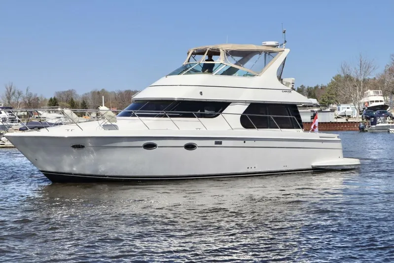  Yacht Photos Pics 2004 Carver 460 Voyager yacht on a calm waterway, surrounded by other boats.