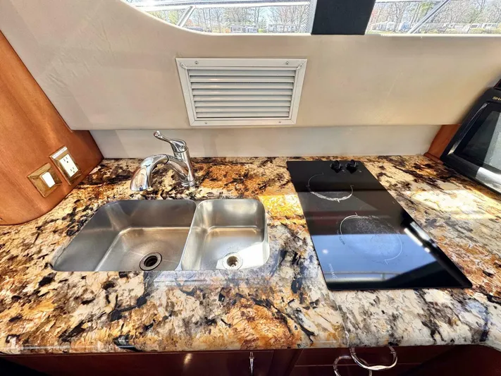  Yacht Photos Pics 2004 Carver 460 Voyager kitchen with granite countertop, dual sink, and electric cooktop.