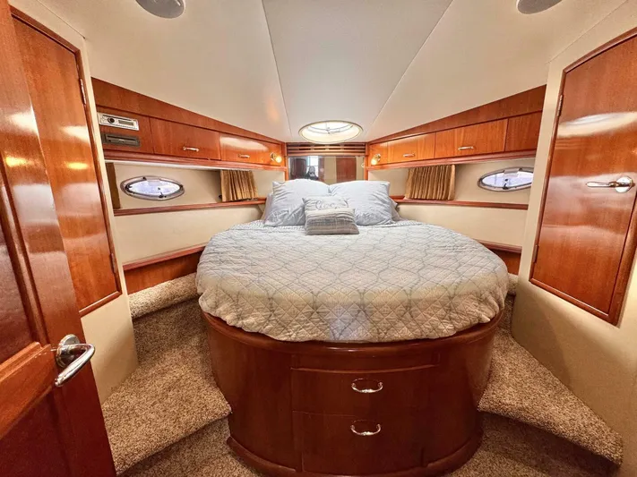  Yacht Photos Pics Luxurious 2004 Carver 460 Voyager bedroom with circular bed and wooden cabinetry.