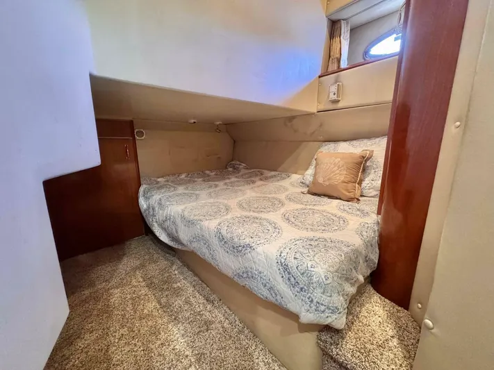  Yacht Photos Pics Cozy bedroom in 2004 Carver 460 Voyager yacht with patterned bedding and wood accents.