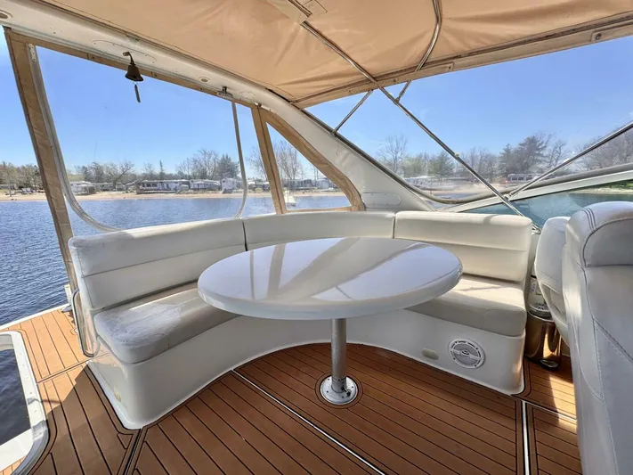  Yacht Photos Pics 2004 Carver 460 Voyager yacht interior with white seating and round table, overlooking water.