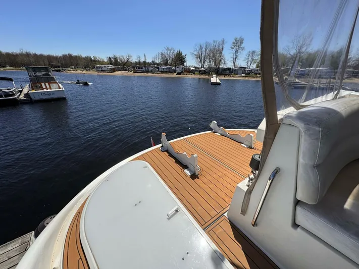  Yacht Photos Pics 2004 Carver 460 Voyager yacht with teak deck, docked by a serene lake.