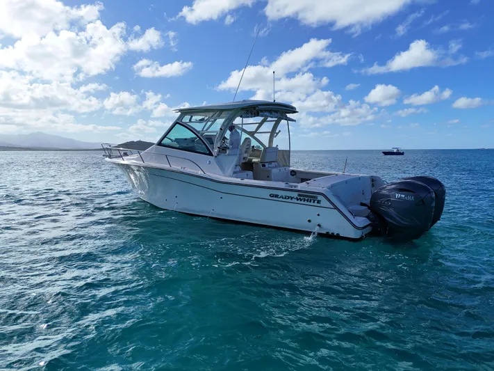  Yacht Photos Pics 2021 Grady-White Express 330 boat on clear blue ocean water under a partly cloudy sky.