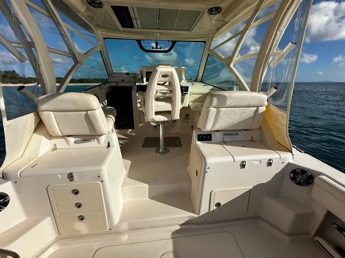  Yacht Photos Pics 2021 Grady-White Express 330 boat interior with seating and helm, on calm water.
