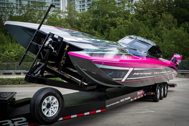  Yacht Photos Pics 2023 MTI 390XR powerboat on trailer, vibrant pink and black design, parked outdoors.