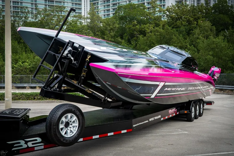  Yacht Photos Pics 2023 MTI 390XR powerboat on trailer, vibrant pink and gray design, parked outdoors.
