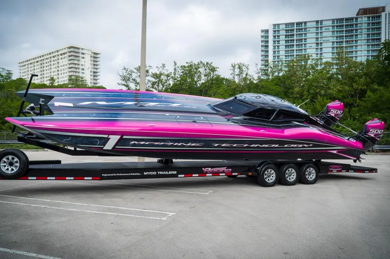  Yacht Photos Pics 2023 MTI 390XR powerboat with vibrant pink and black design on a trailer.
