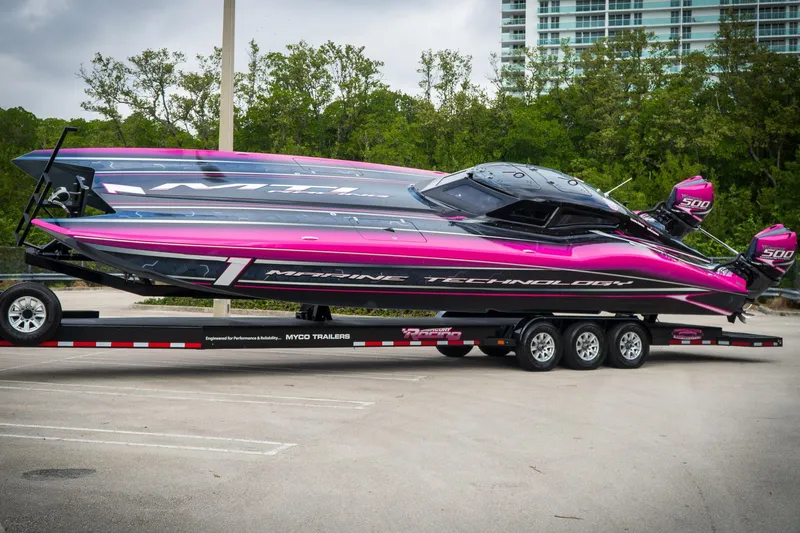  Yacht Photos Pics 2023 MTI 390XR powerboat with vibrant pink and black design on a trailer.