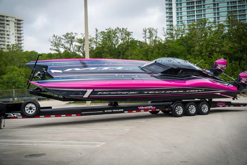  Yacht Photos Pics 2023 MTI 390XR powerboat with vibrant pink and black design on a trailer.