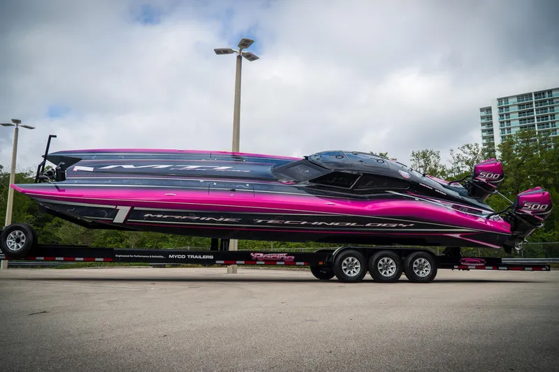  Yacht Photos Pics 2023 MTI 390XR powerboat with vibrant pink and black design on a trailer.