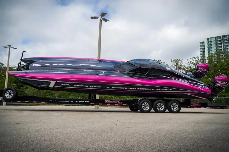  Yacht Photos Pics 2023 MTI 390XR powerboat with vibrant pink and black design on a trailer.