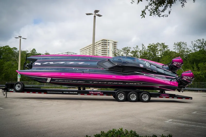  Yacht Photos Pics 2023 MTI 390XR powerboat with vibrant pink and black design on a trailer.