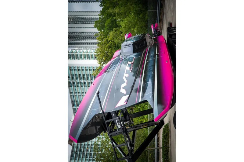  Yacht Photos Pics 2023 MTI 390XR powerboat with vibrant pink and black design, displayed outdoors.