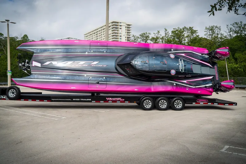  Yacht Photos Pics 2023 MTI 390XR powerboat on trailer, vibrant pink and black design, parked outdoors.
