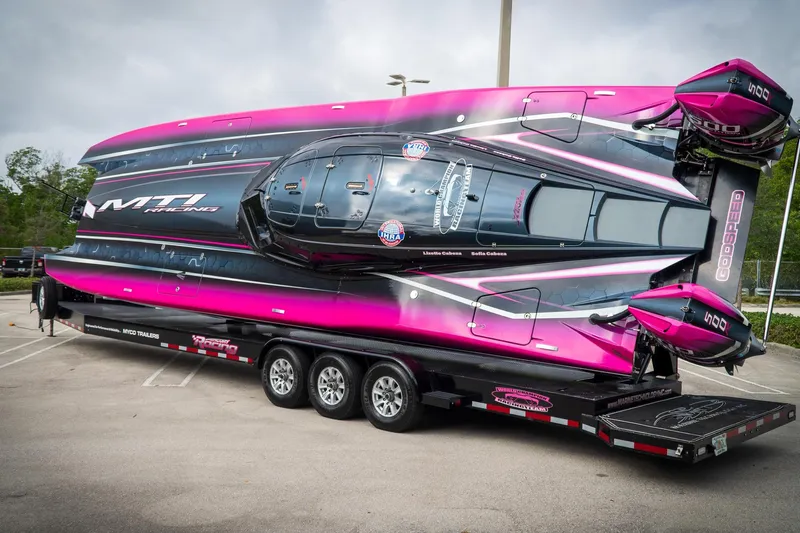  Yacht Photos Pics 2023 MTI 390XR powerboat on trailer, vibrant pink and black design, parked outdoors.