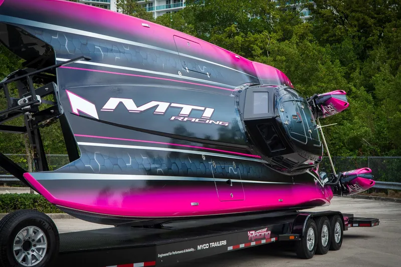  Yacht Photos Pics 2023 MTI 390XR racing boat on trailer, vibrant pink and black design.