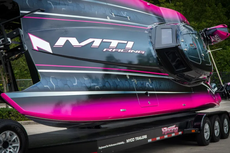  Yacht Photos Pics 2023 MTI 390XR racing boat with vibrant pink and black design on trailer.