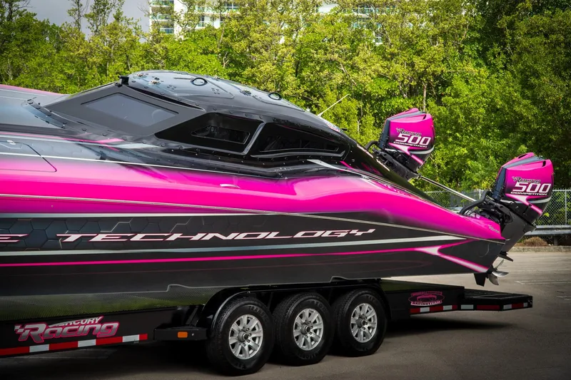  Yacht Photos Pics 2023 MTI 390XR powerboat with vibrant pink and black design on a trailer.