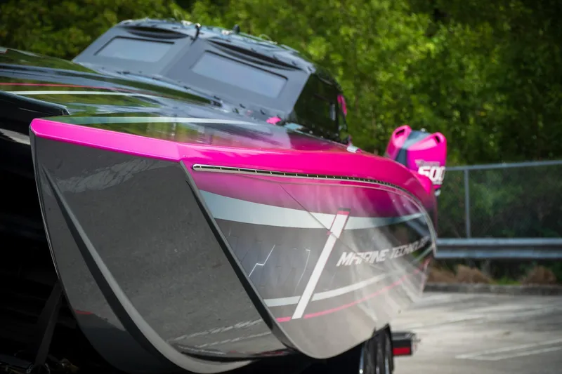  Yacht Photos Pics 2023 MTI 390XR powerboat with vibrant pink and gray design, parked outdoors.