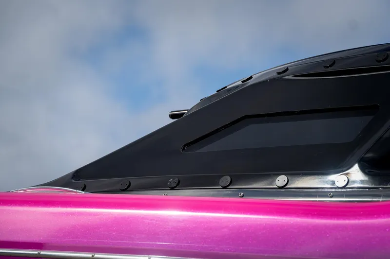  Yacht Photos Pics Close-up of 2023 MTI 390XR boat with sleek black and pink design.