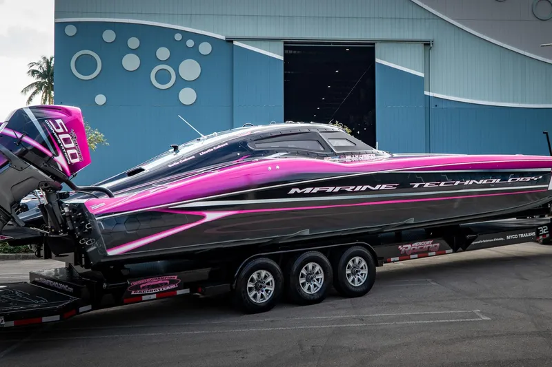  Yacht Photos Pics 2023 MTI 390XR powerboat with vibrant pink and black design on a trailer.