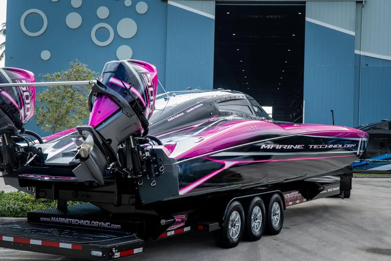  Yacht Photos Pics 2023 MTI 390XR powerboat with vibrant pink and black design on a trailer.