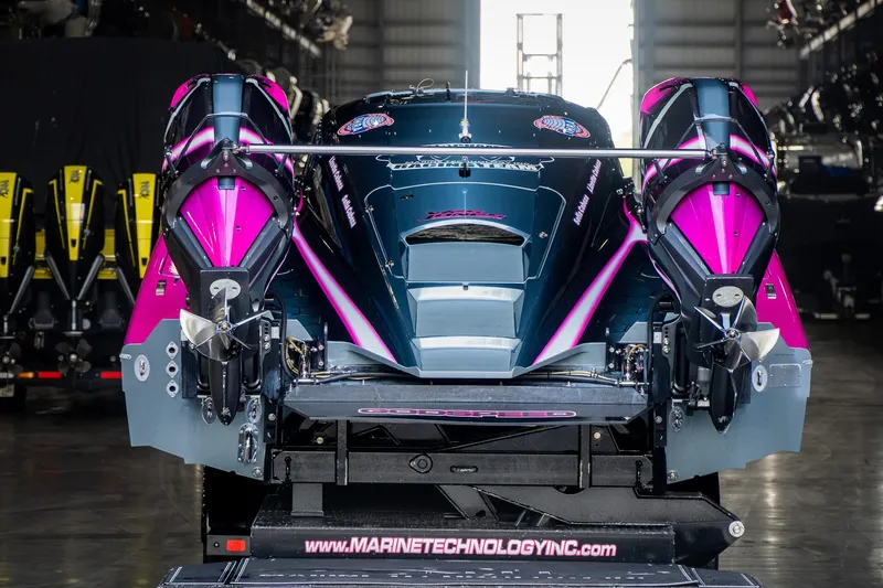  Yacht Photos Pics 2023 MTI 390XR powerboat with vibrant pink and black design in a showroom.