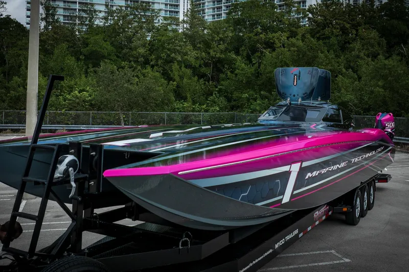  Yacht Photos Pics 2023 MTI 390XR powerboat with vibrant pink and black design on a trailer.