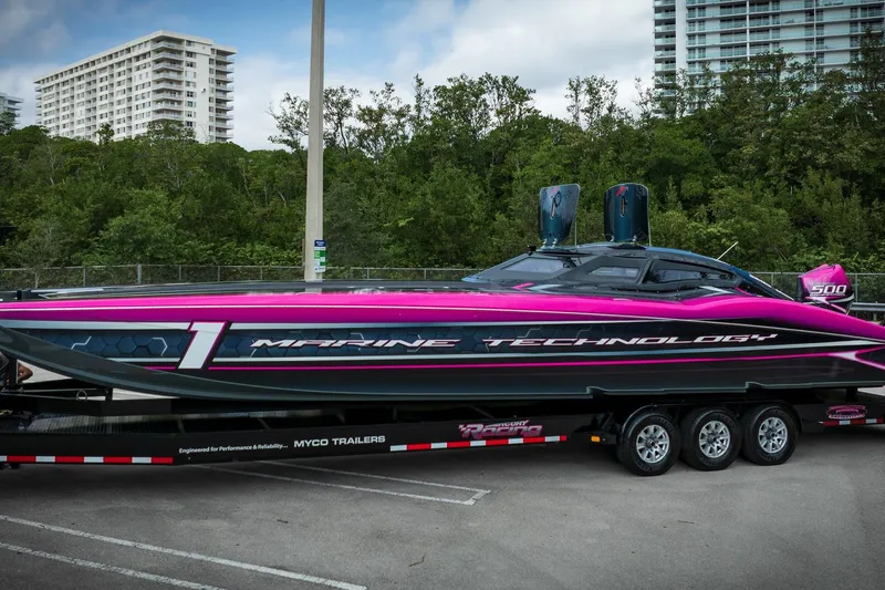  Yacht Photos Pics 2023 MTI 390XR powerboat with vibrant pink and black design on a trailer.