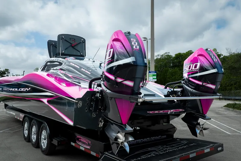  Yacht Photos Pics 2023 MTI 390XR powerboat with vibrant pink and black design on a trailer.