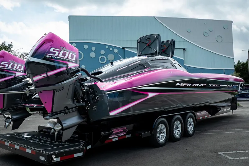  Yacht Photos Pics 2023 MTI 390XR powerboat with vibrant pink and black design on a trailer.