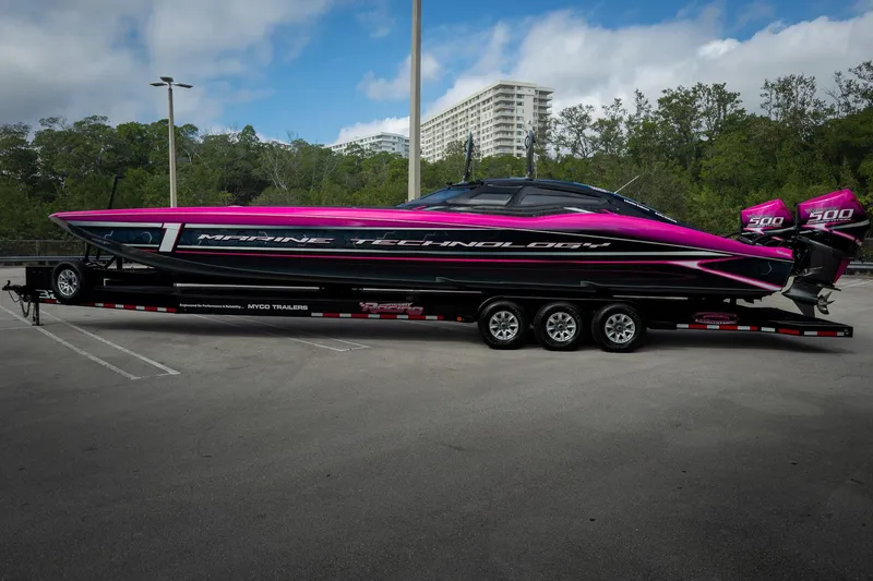  Yacht Photos Pics 2023 MTI 390XR powerboat with vibrant pink and black design on a trailer.