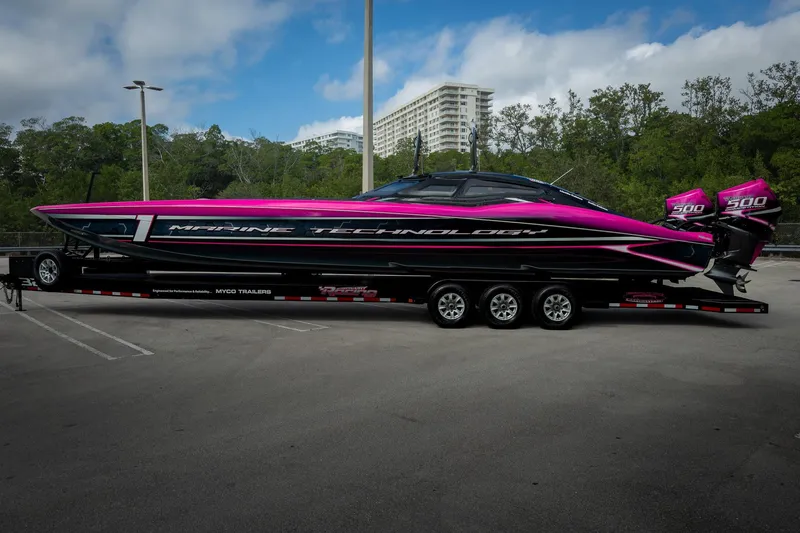  Yacht Photos Pics 2023 MTI 390XR powerboat with vibrant pink and black design on a trailer.