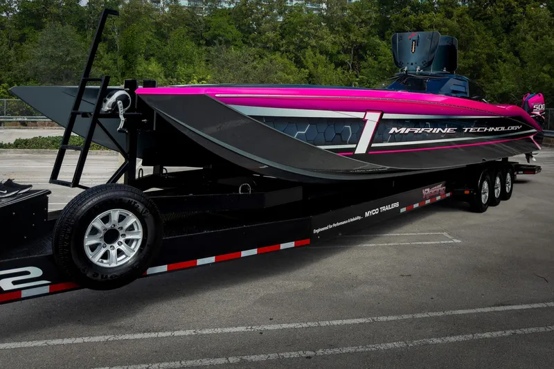  Yacht Photos Pics 2023 MTI 390XR powerboat on trailer, vibrant pink and black design.
