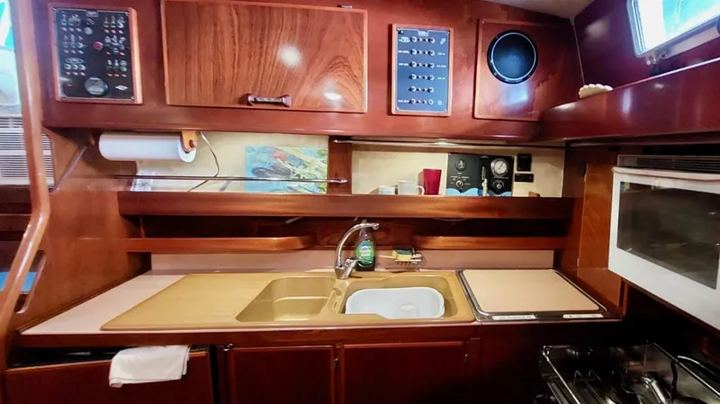 Forever Young Yacht Photos Pics Interior of 2000 Amel Super Maramu 2000 yacht kitchen with wood cabinetry and modern appliances.