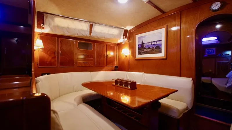 Forever Young Yacht Photos Pics Luxurious interior of 2000 Amel Super Maramu yacht with elegant wood and white seating.