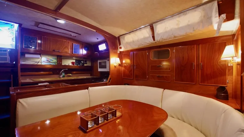 Forever Young Yacht Photos Pics Luxurious interior of 2000 Amel Super Maramu yacht with elegant wood finish and cozy seating.