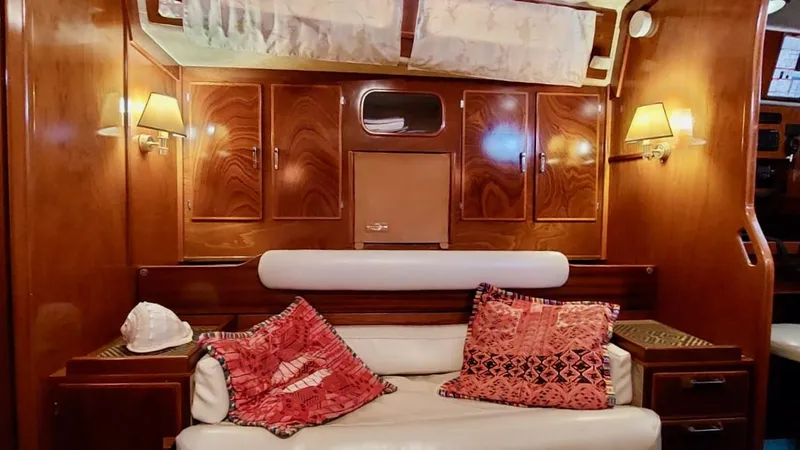 Forever Young Yacht Photos Pics Luxurious interior of 2000 Amel Super Maramu yacht with elegant wood paneling and cozy seating.