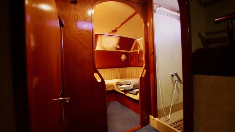 Forever Young Yacht Photos Pics Cozy cabin interior of 2000 Amel Super Maramu yacht with wooden finish and bed.
