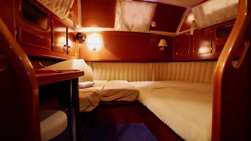 Forever Young Yacht Photos Pics Luxurious cabin interior of 2000 Amel Super Maramu yacht with wood finish and cozy bedding.
