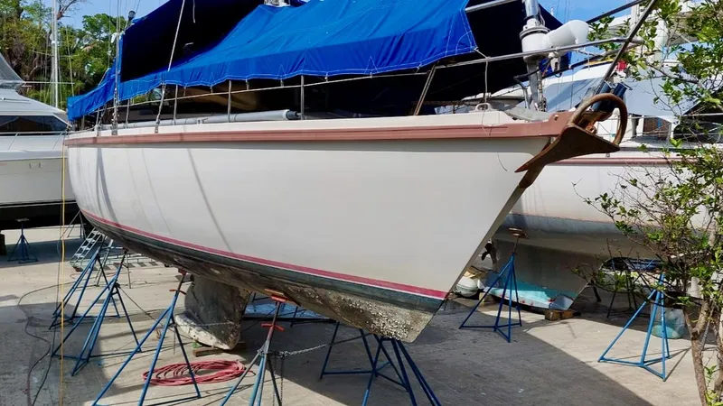 Forever Young Yacht Photos Pics Amel Super Maramu 2000 sailboat on stands, covered with a blue tarp.